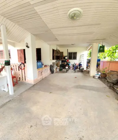 Spacious covered parking area with bicycles and storage space in a residential property.
