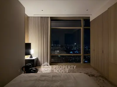 Luxurious bedroom with stunning city view, modern decor, and ambient lighting for a serene retreat.