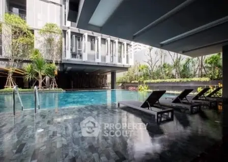 Luxurious modern apartment pool area with sleek design and lush greenery.