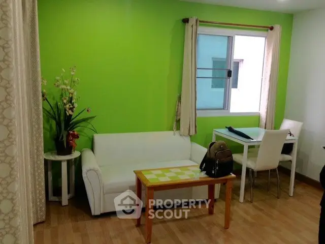 Charming living room with vibrant green accent wall and cozy white sofa