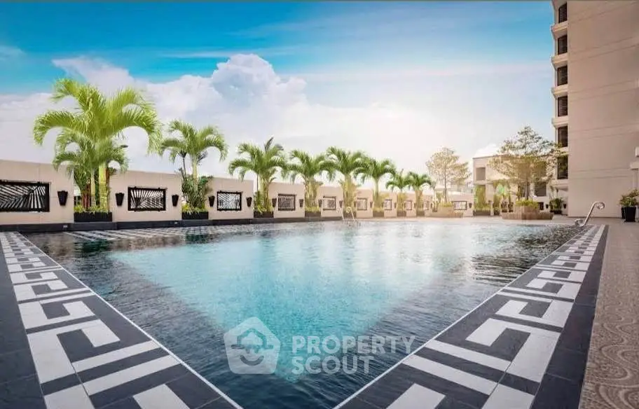 Luxurious outdoor pool area with palm trees and elegant design in a modern residential complex.