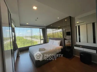 Spacious modern bedroom with large windows offering stunning views and elegant decor.