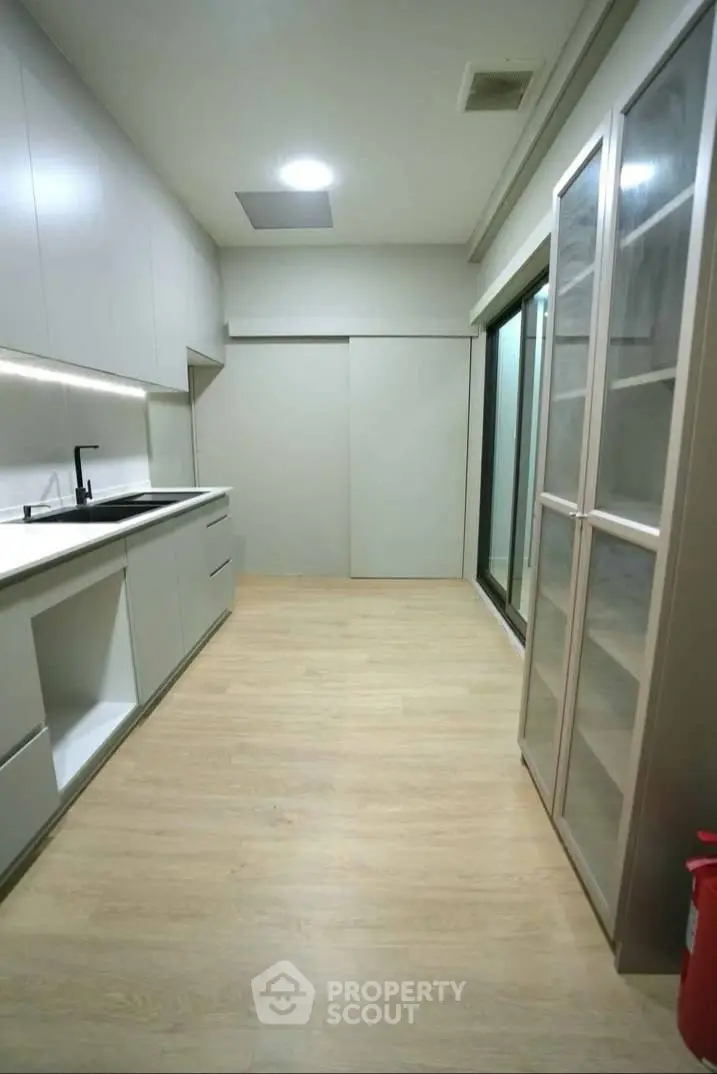 Modern kitchen with sleek cabinetry and ample storage space in a contemporary apartment.