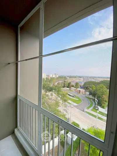 Spacious balcony with panoramic view of cityscape and greenery.