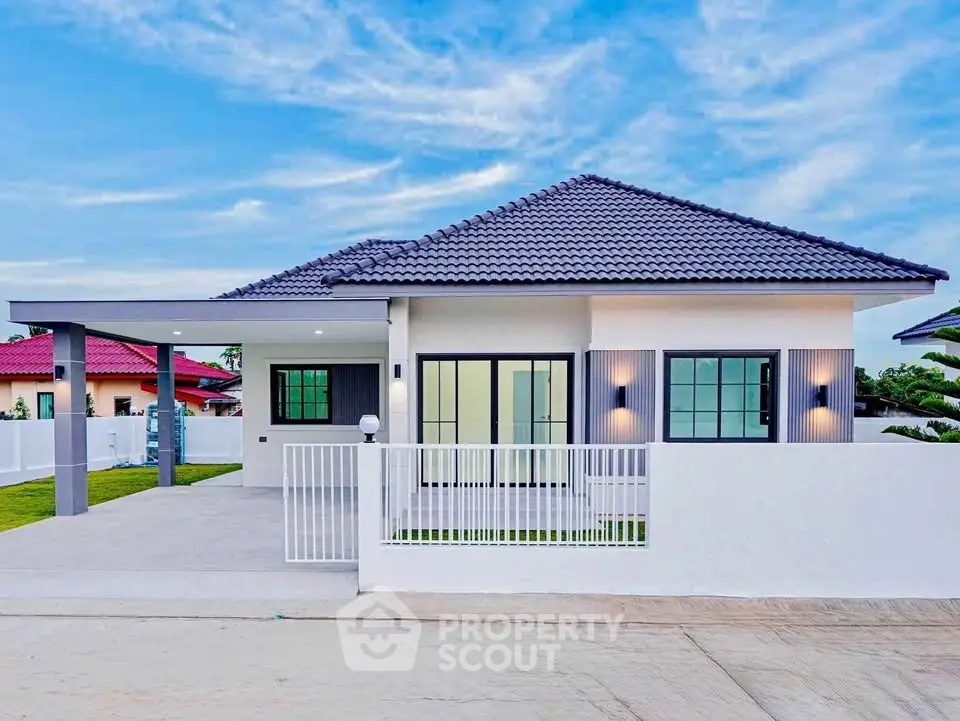 Modern single-story home with sleek design and spacious driveway in a serene neighborhood.