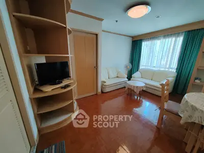 Cozy living room with natural light, wooden flooring, and comfortable seating.