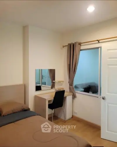 Cozy bedroom with modern decor and study desk, perfect for relaxation and productivity.