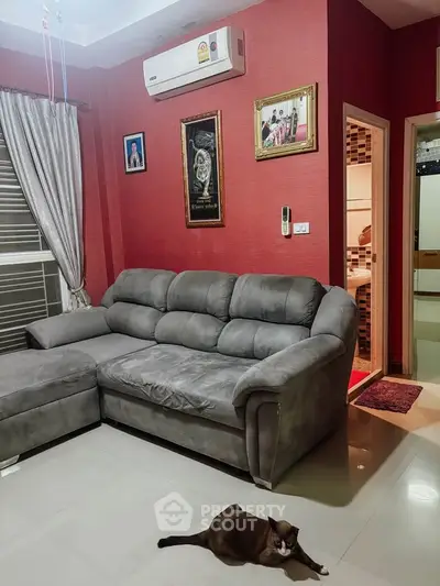 Cozy living room with plush gray sofa and air conditioning, perfect for relaxation.