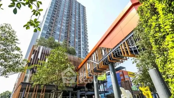 Modern high-rise building with unique architectural design and lush greenery.