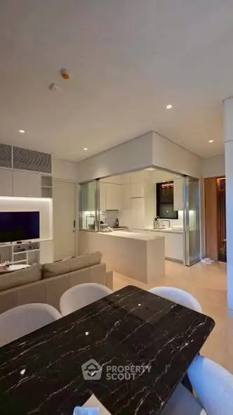 Modern open-plan living room and kitchen with sleek design and elegant furnishings.