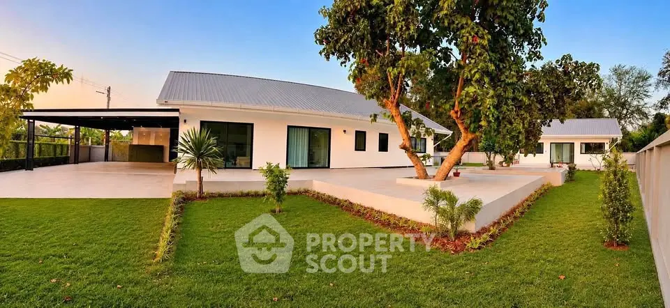 Modern single-story home with lush green lawn and spacious outdoor area, perfect for family living.