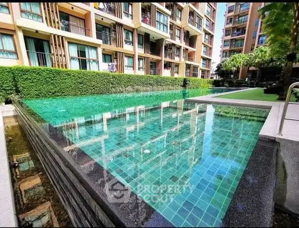 Luxurious condominium with stunning pool and lush greenery, perfect for modern living.