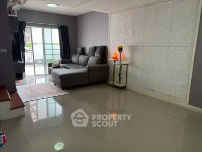 Spacious living room with modern decor and balcony access in a stylish apartment.