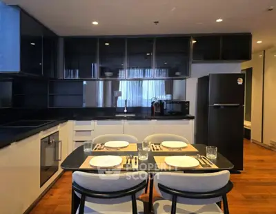 Modern kitchen with sleek black cabinets and dining area
