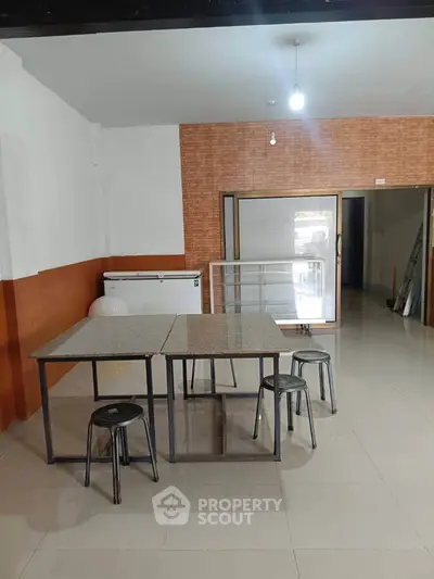 Spacious interior with modern tables and chairs, ideal for versatile use in a commercial or residential setting.