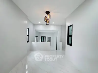 Spacious modern interior with elegant lighting and sleek white flooring, perfect for contemporary living.