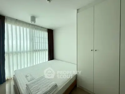 Bright and airy bedroom with large window and built-in wardrobe, perfect for a cozy retreat.