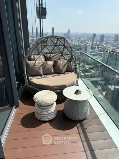 Luxurious high-rise balcony with stunning city view and cozy seating area.