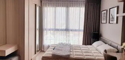 Modern bedroom with large window and stylish decor in a contemporary apartment.
