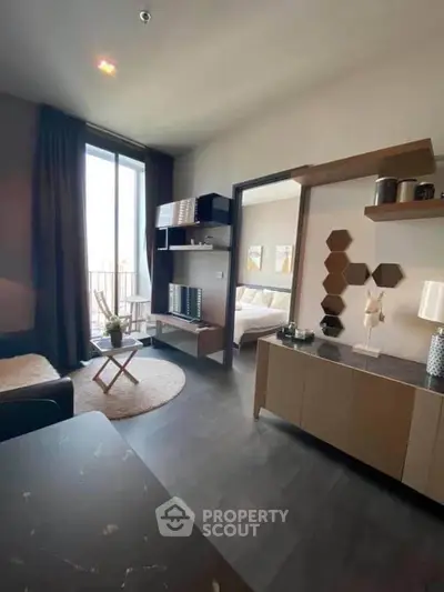 Modern apartment interior with stylish living room and bedroom view, featuring sleek furniture and natural light.