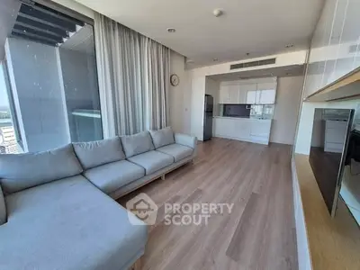 Modern open-plan living room with sleek kitchen and large windows