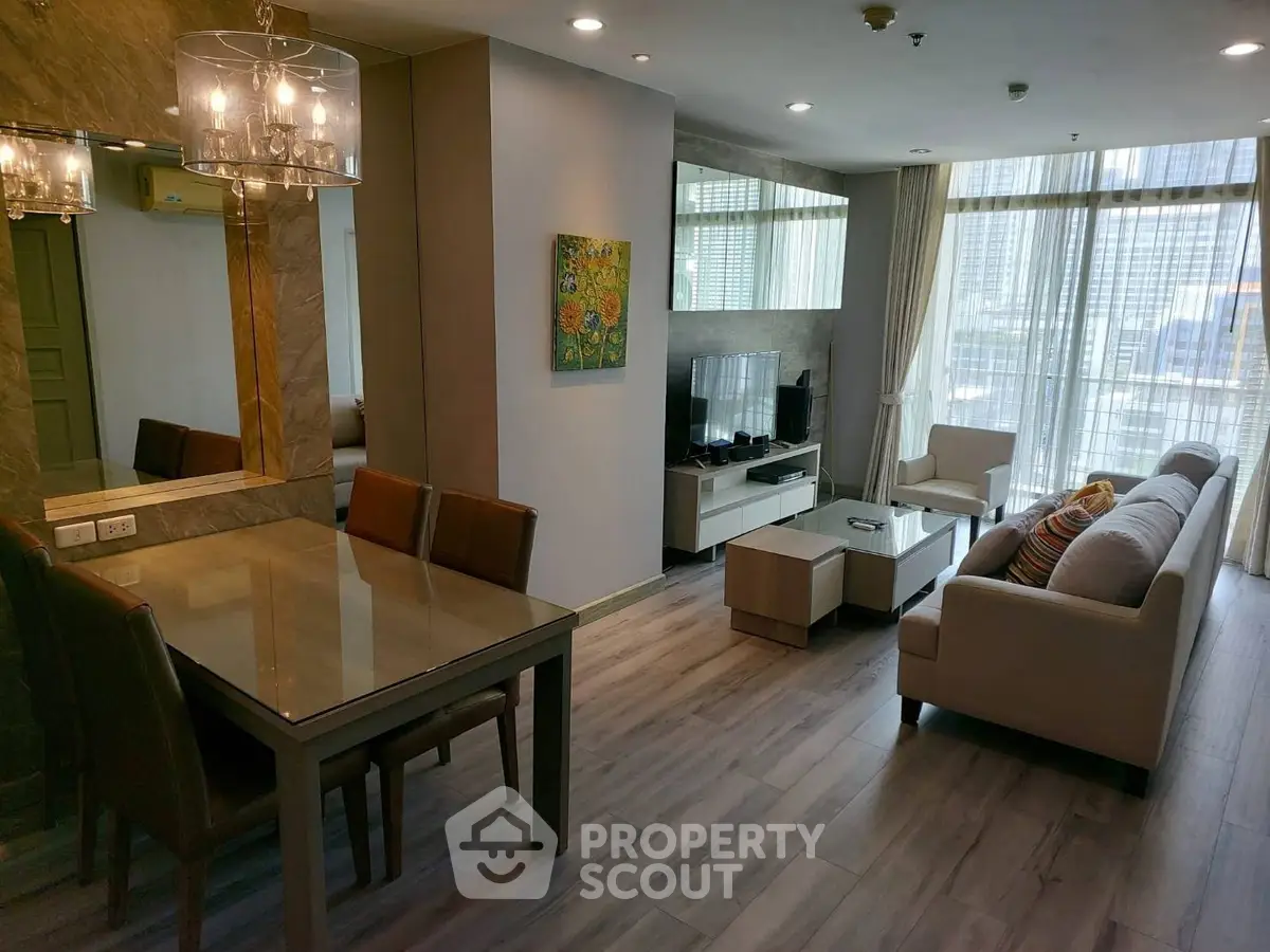 Modern living room with elegant dining area and large windows offering city views.
