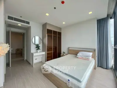 Modern bedroom with large windows and minimalist furniture in high-rise apartment.