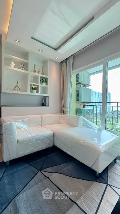 Modern living room with white sectional sofa and balcony view in a stylish apartment.