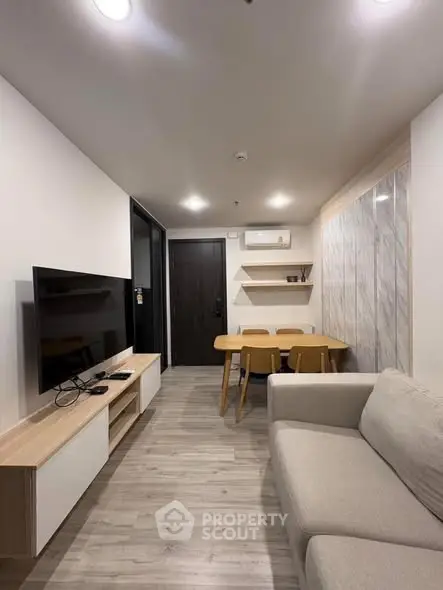 Modern living room with sleek furniture and wall-mounted TV in a stylish apartment.