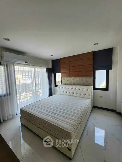 Luxurious bedroom with elegant decor and large windows offering natural light
