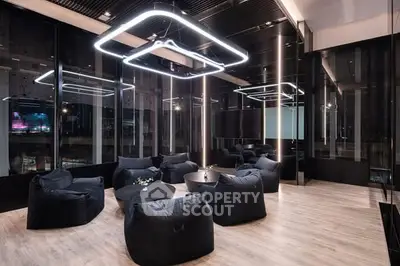 Modern lounge area with sleek lighting and plush seating in a luxury building.