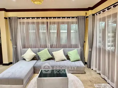 Elegant living room with plush gray sofa, stylish curtains, and modern decor accents.