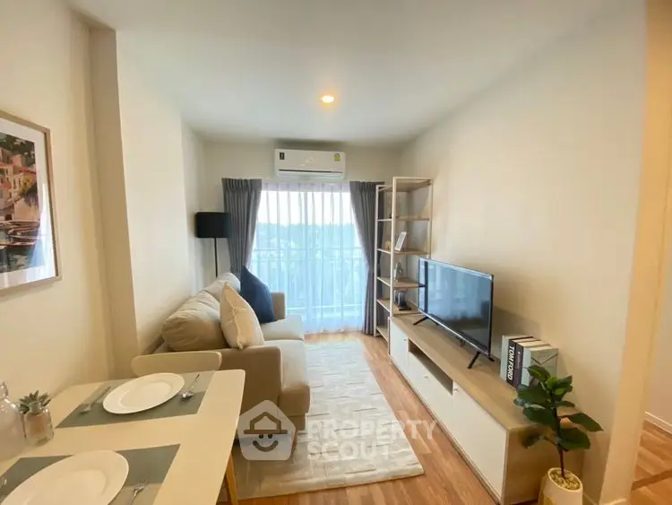 Modern living room with cozy sofa, TV, and dining area in bright apartment