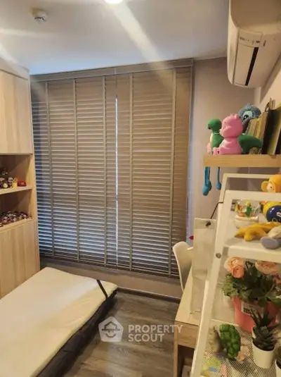 Cozy children's bedroom with wooden flooring, built-in shelves, and playful decor.