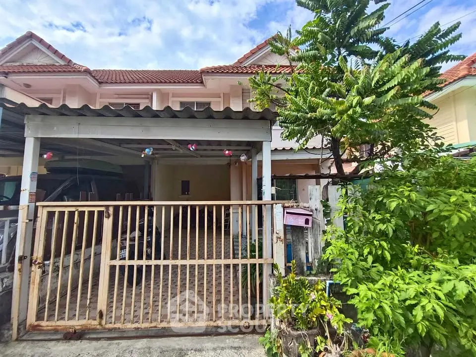 Charming townhouse with gated entrance and lush greenery, perfect for family living.