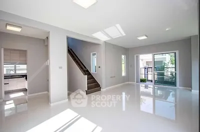 Spacious modern living room with glossy floors and large windows offering natural light.