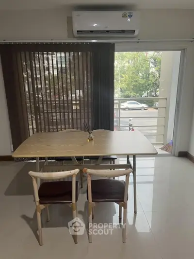 Modern dining area with table, chairs, and balcony view in a stylish apartment.