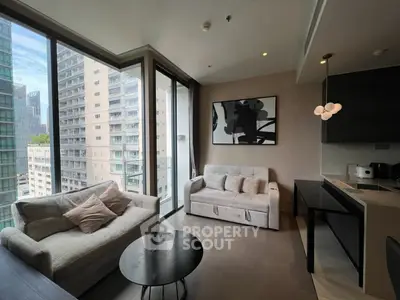 Modern living room with large windows and stylish furniture in a high-rise apartment.