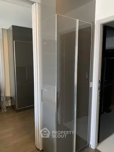 Modern bathroom with sleek glass shower enclosure and wooden flooring
