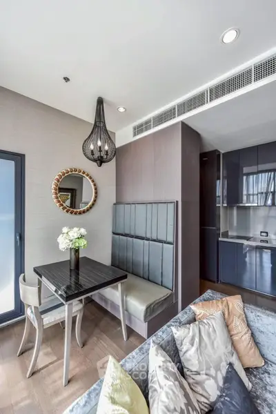 Modern dining area with elegant decor and open kitchen layout in a stylish apartment.