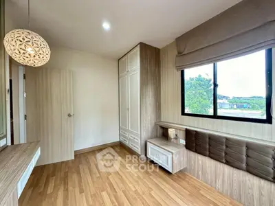 Spacious bedroom with wooden flooring and large window offering scenic views