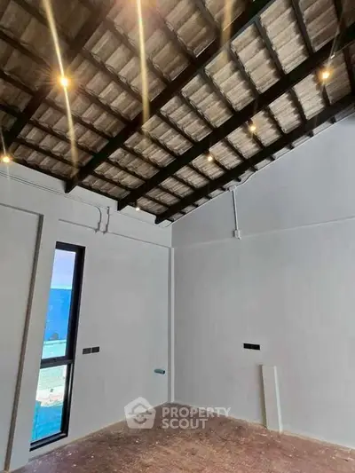 Spacious room with high ceiling and modern lighting, perfect for customization.