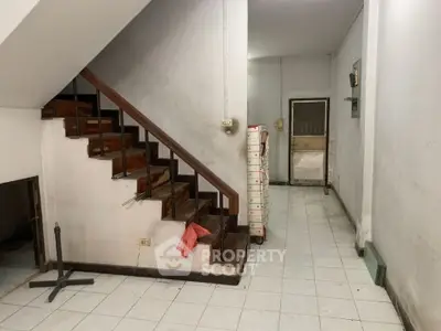 Spacious interior with staircase and tiled flooring, ideal for renovation opportunities.