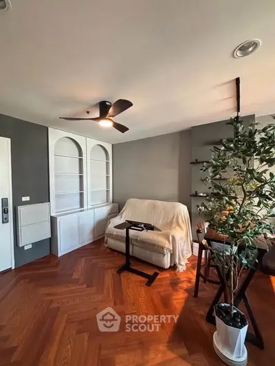 Charming living room with elegant wooden flooring and cozy seating area, perfect for relaxation.