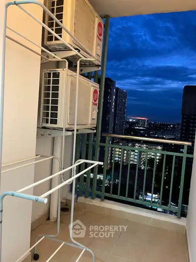 High-rise balcony with city view and air conditioning units at dusk