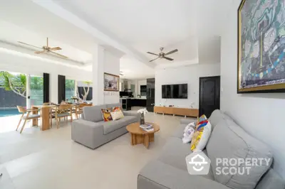 Spacious open-plan living area with modern furniture, seamlessly connecting to an outdoor pool, perfect for entertaining and relaxation.