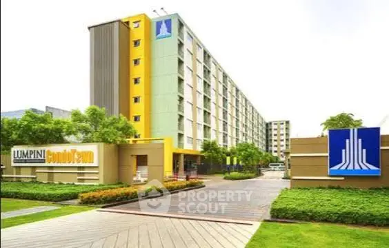 Modern condominium building with lush landscaping and vibrant exterior design.