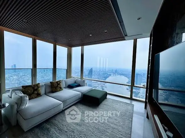Luxurious living room with panoramic city view and modern furnishings.