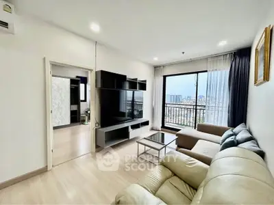 Spacious living room with modern furniture and city view from large window.