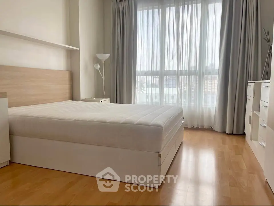 Spacious bedroom with natural light and modern furnishings